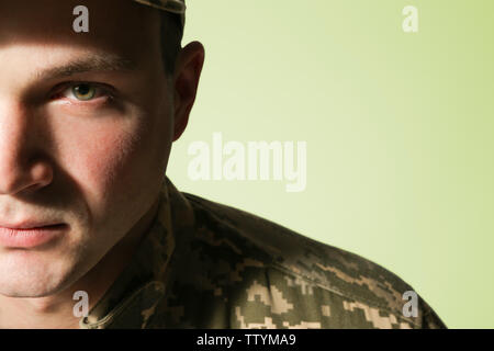 Soldier in camouflage on grey background, closeup Stock Photo