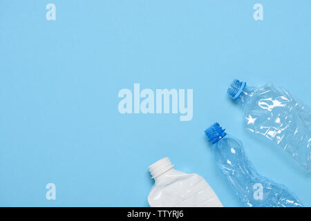 Single use crushed plastic bottles on blue background with copy space. Plastic pollution. Recycle reuse template. Stock Photo