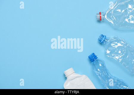 Single use crushed plastic water bottles on blue background with copy space. Plastic pollution. Recycle reuse template. Stock Photo