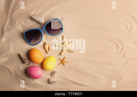 Easter eggs with sunglasses on sand Stock Photo