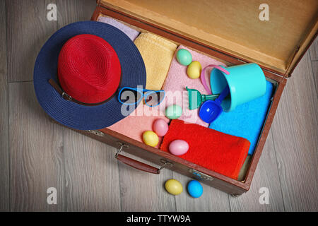 Easter eggs with open suitcase on floor Stock Photo
