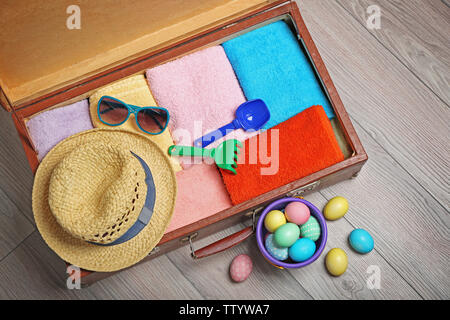 Easter eggs with open suitcase on floor Stock Photo