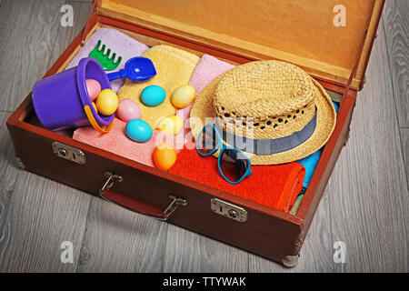 Easter eggs with open suitcase on floor Stock Photo