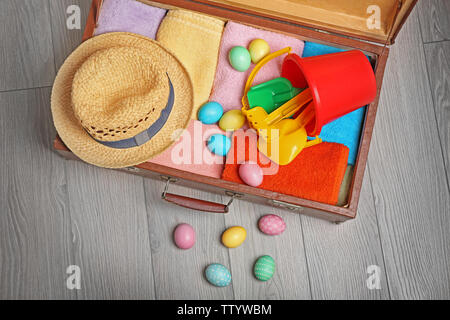 Easter eggs with open suitcase on floor Stock Photo