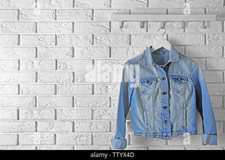 Denim jacket hanging on brick wall Stock Photo