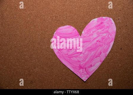 love heart symbol painted pink on a cork board Stock Photo