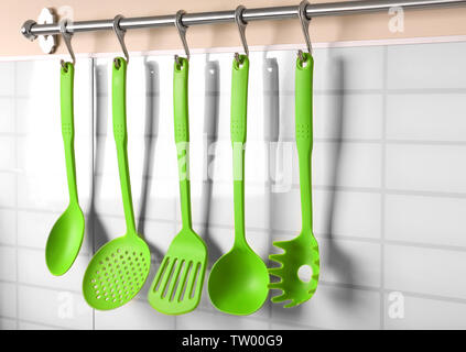 Set of kitchen utensils hanging on the wall Stock Photo