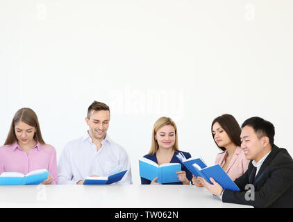 Group of people reading books while sitting at table Stock Photo