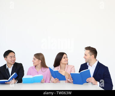 Group of people reading books while sitting at table Stock Photo