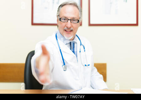 Doctor welcoming a patient in his studio, handshake Stock Photo