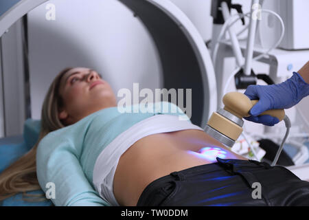 Young woman undergoing laser treatment in modern clinic Stock Photo