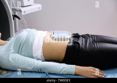 Magnetic therapy for young female patient in modern clinic Stock Photo