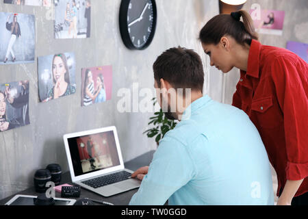 Two young photographers discussing picture on laptop display Stock Photo