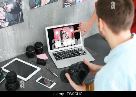Two young photographers discussing picture on laptop display Stock Photo
