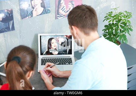 Two young photographers discussing picture on laptop display Stock Photo