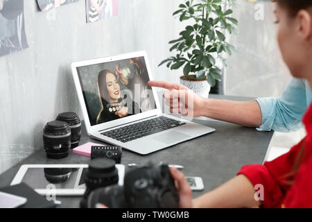 Two young photographers discussing picture on laptop display Stock Photo