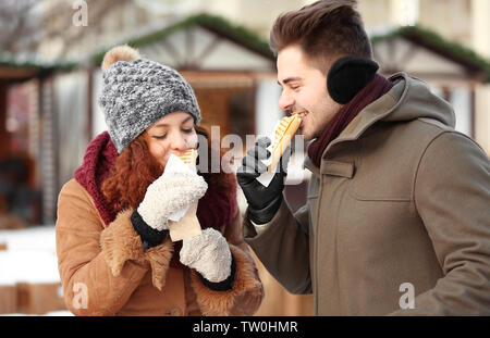 Cute couple having lunch break on winter market Stock Photo