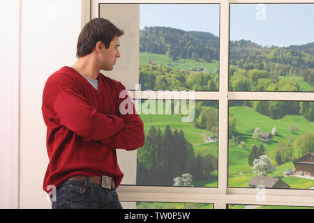 Man looking out through a window Stock Photo