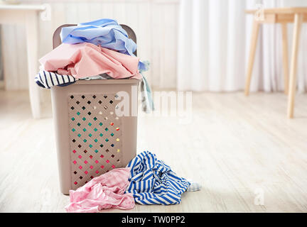 Pile of clothes in plastic laundry basket indoors Stock Photo