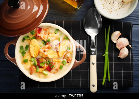 Delicious beer cheese soup with croutons and fried bacon on table Stock Photo