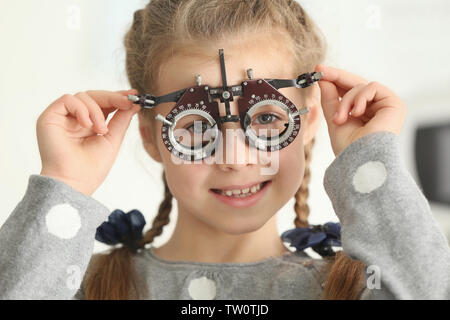 Cute little girl with trial frame in ophthalmologist's office Stock Photo