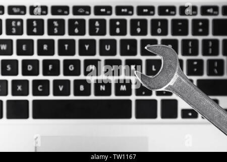 Wrench on laptop keyboard background Stock Photo