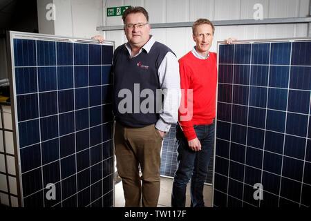 Ben Harrison, managing partner of mypower, with Neil Stott, business development manager, and two full sized solar panels, at the solar panel installa Stock Photo