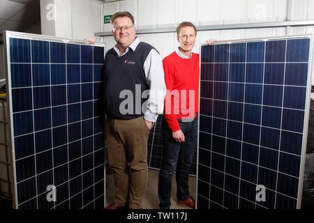 Ben Harrison, managing partner of mypower, with Neil Stott, business development manager, and two full sized solar panels, at the solar panel installa Stock Photo