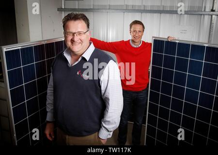Ben Harrison, managing partner of mypower, with Neil Stott, business development manager, and two full sized solar panels, at the solar panel installa Stock Photo