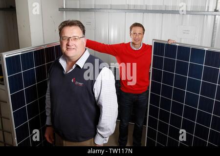 Ben Harrison, managing partner of mypower, with Neil Stott, business development manager, and two full sized solar panels, at the solar panel installa Stock Photo