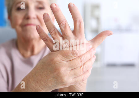 Elderly woman suffering from pain in hand, closeup Stock Photo