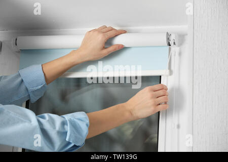 Woman hands installing window blinds, closeup Stock Photo
