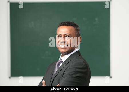 Confident Indian teacher in classroom Stock Photo