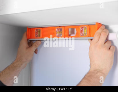 Male hands making window measurements using  building level Stock Photo