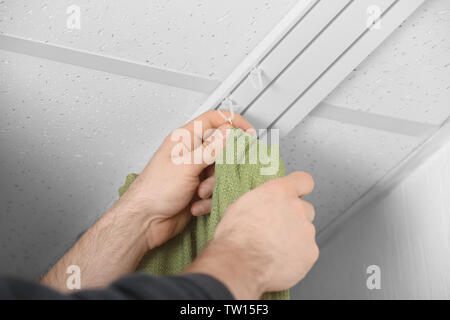 Male hands installing curtains over window Stock Photo