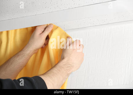 Male hands installing curtains over window Stock Photo