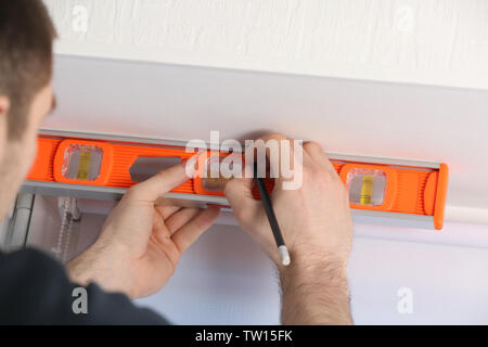 Male hands making window measurements using  building level Stock Photo