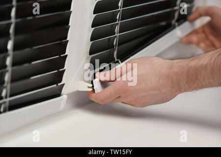 Male hands installing window blinds Stock Photo