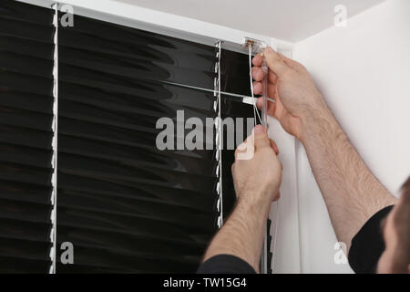 Male hands installing window blinds Stock Photo