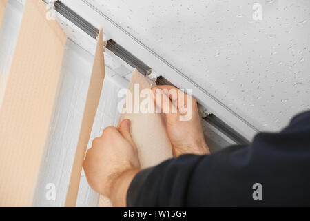 Male hands installing vertical blinds Stock Photo