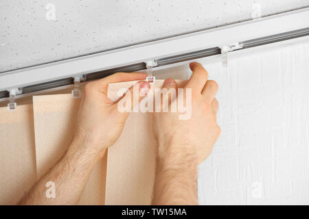 Male hands installing vertical blinds Stock Photo