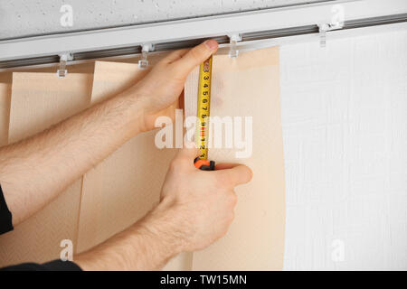 Male hands measuring vertical blinds Stock Photo