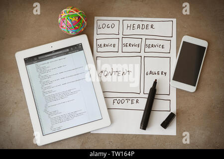 Tablet with programming code for website on table Stock Photo