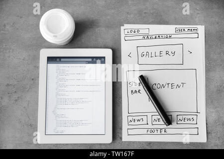Tablet with programming code for website on table Stock Photo