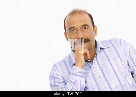 Portrait of a businessman with hand on chin Stock Photo