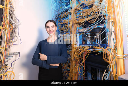 Beautiful young engineer with clipboard in server room Stock Photo