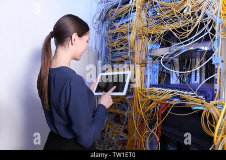 Beautiful young engineer with tablet computer in server room Stock Photo