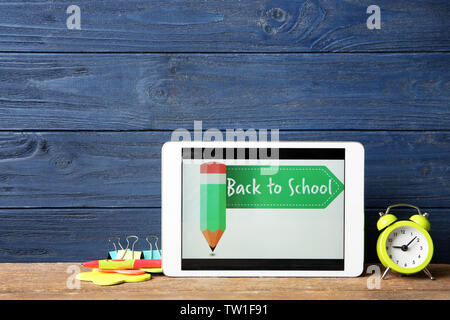 Tablet with BACK TO SCHOOL message and stationery on wooden table Stock Photo