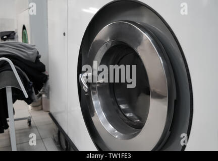 Industrial laundry washing machine in dry cleaner's workshop, closeup Stock Photo