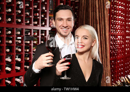 Happy couple drinking in modern wine cellar Stock Photo